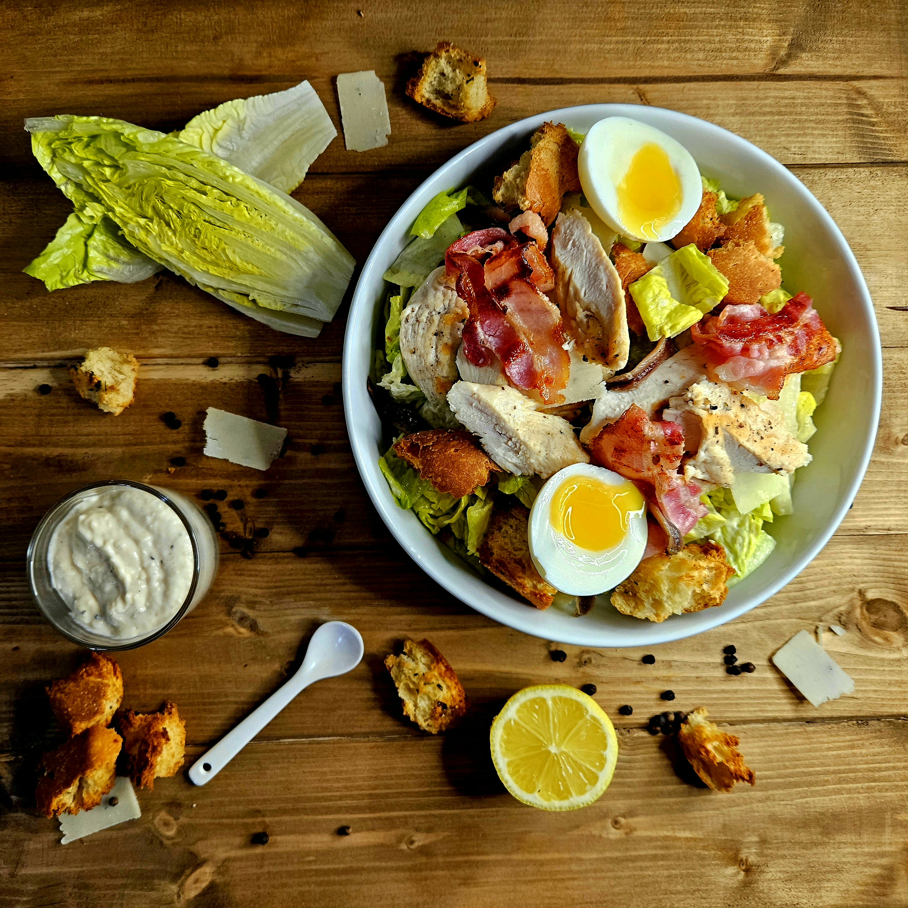 Classic Caesar Chicken with Homemade Dressing. The dish is topped with grilled chicken, bacon, anchovies, and a boiled egg.